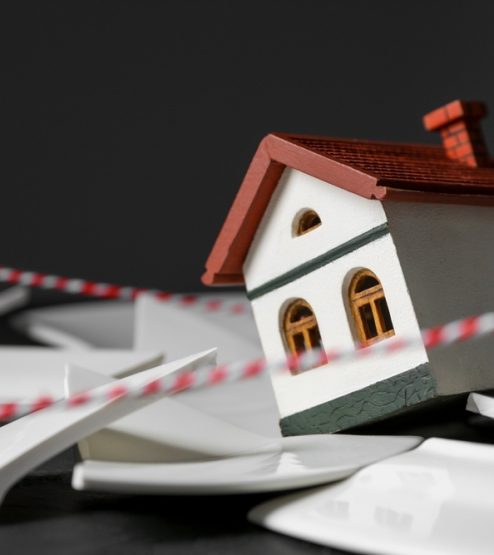 House,Model,And,Broken,Dishes,On,Black,Table,Depicting,Destruction
